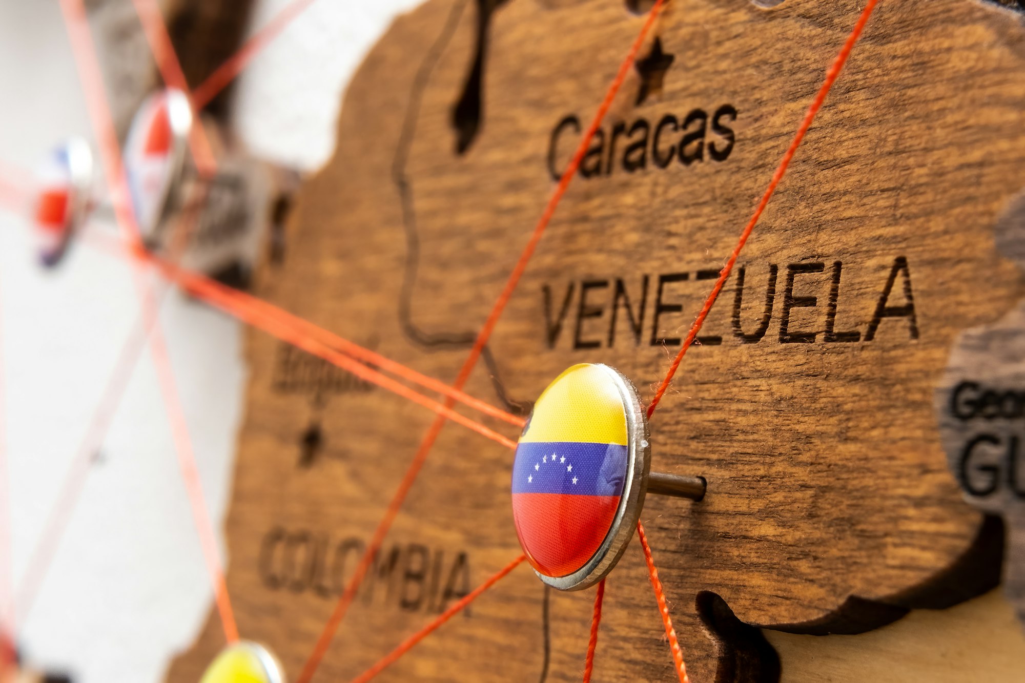 Venezuela flag pins and red thread for traveling and planning trip.